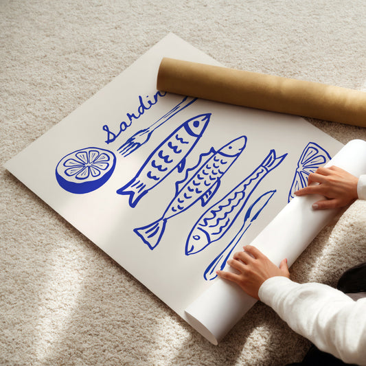 Person unrolling a poster with blue fish illustrations on a beige carpet