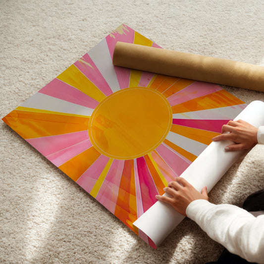 Person unrolling a colorful sun art print on a carpeted floor
