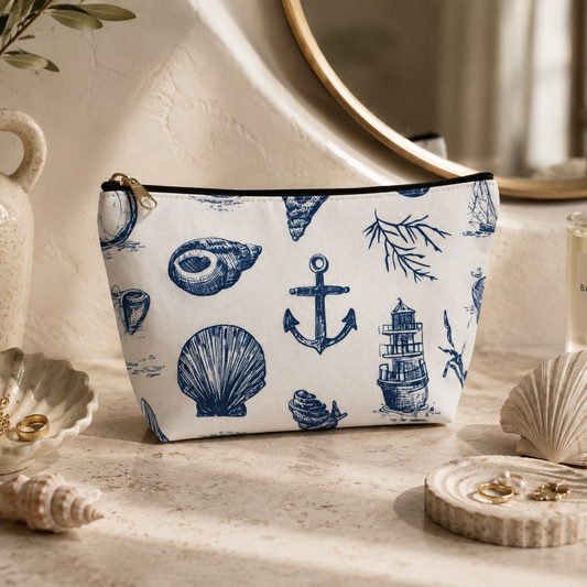 Cosmetic bag with nautical design on a decorative surface with seashells and a mirror.