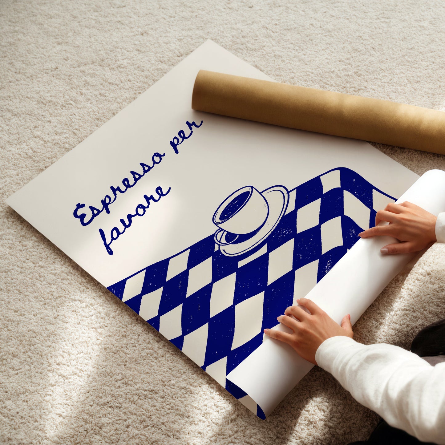 Person unrolling a poster with a coffee-themed design on a light-colored floor.