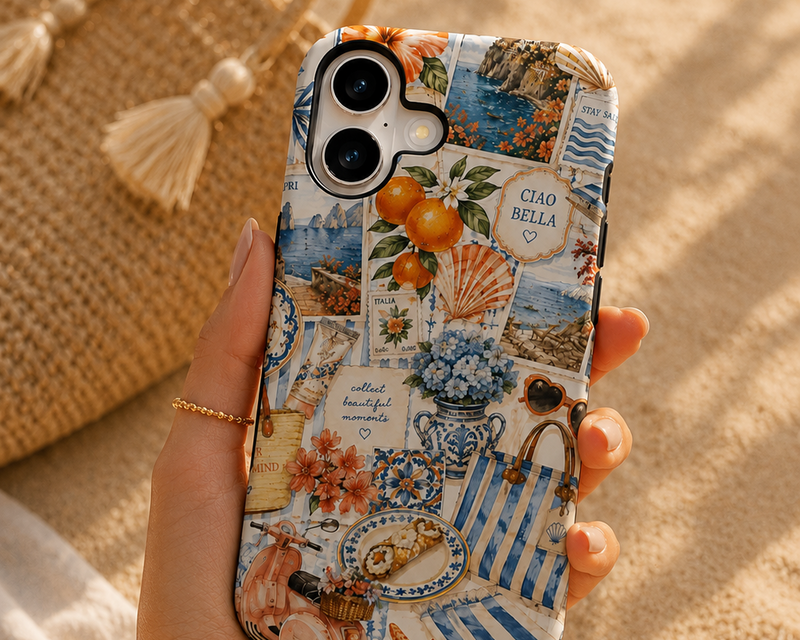 Phone case with travel-themed design held by a hand on sandy background