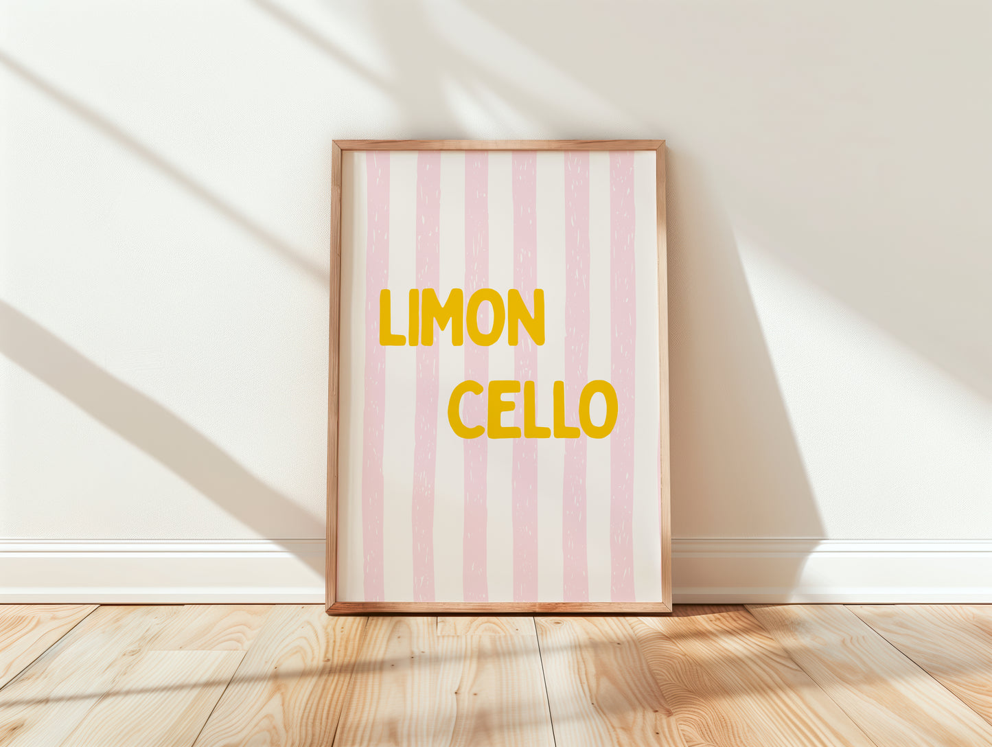 Framed artwork with 'Limon Cello' text on a pink and white striped background, placed on a wooden floor
