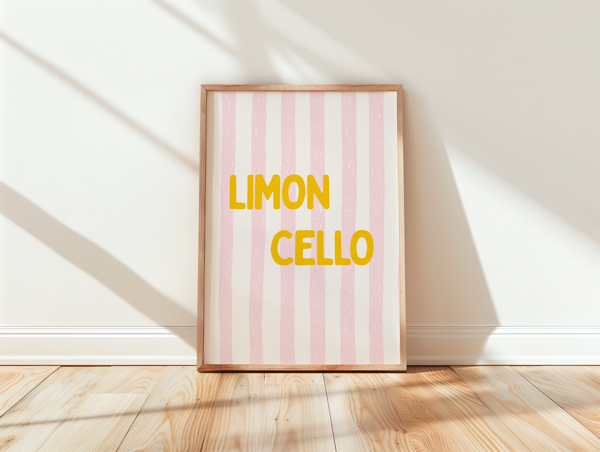 Framed artwork with 'Limon Cello' text on a pink and white striped background, placed on a wooden floor