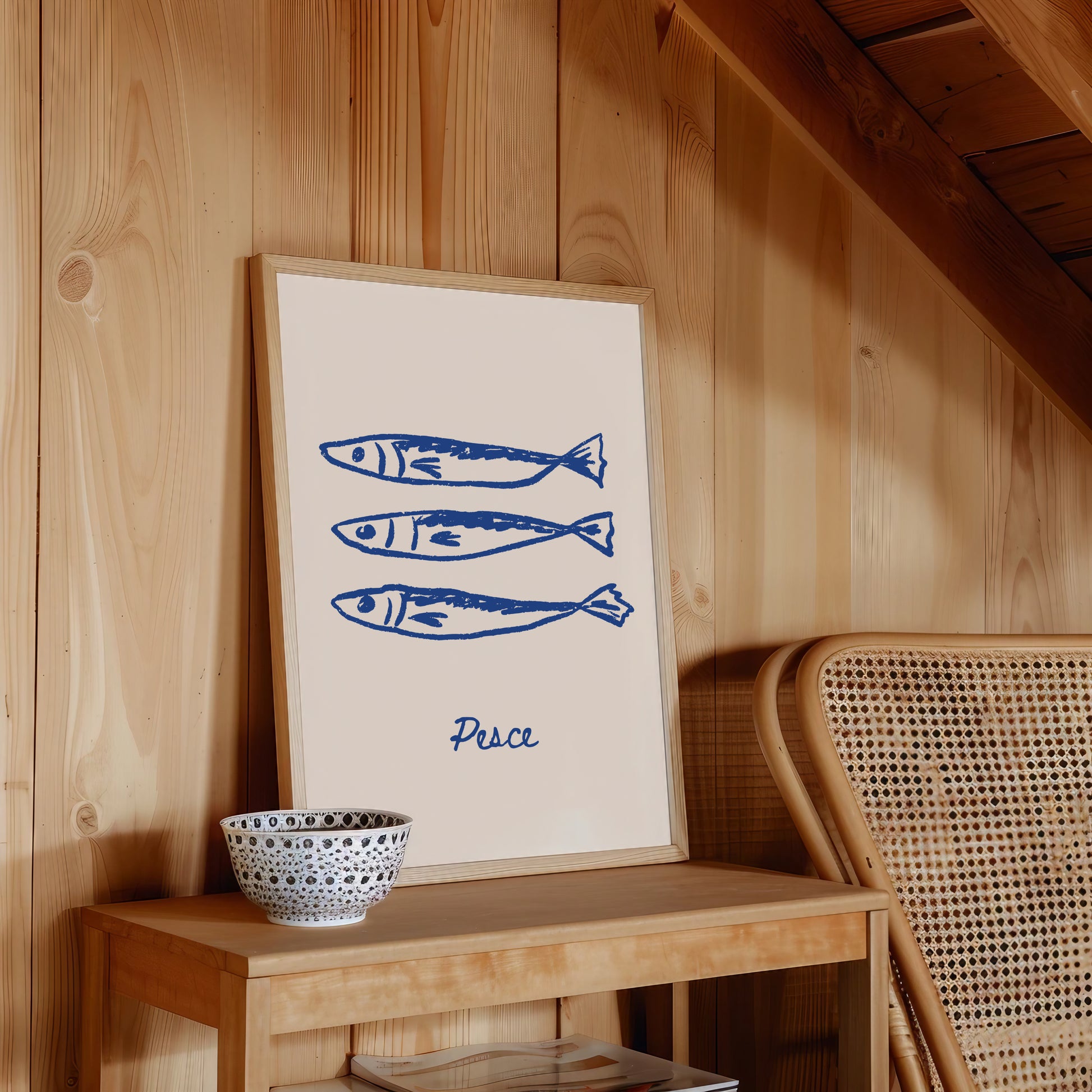 Framed artwork with blue fish illustrations and 'Pesce' text on a wooden shelf.