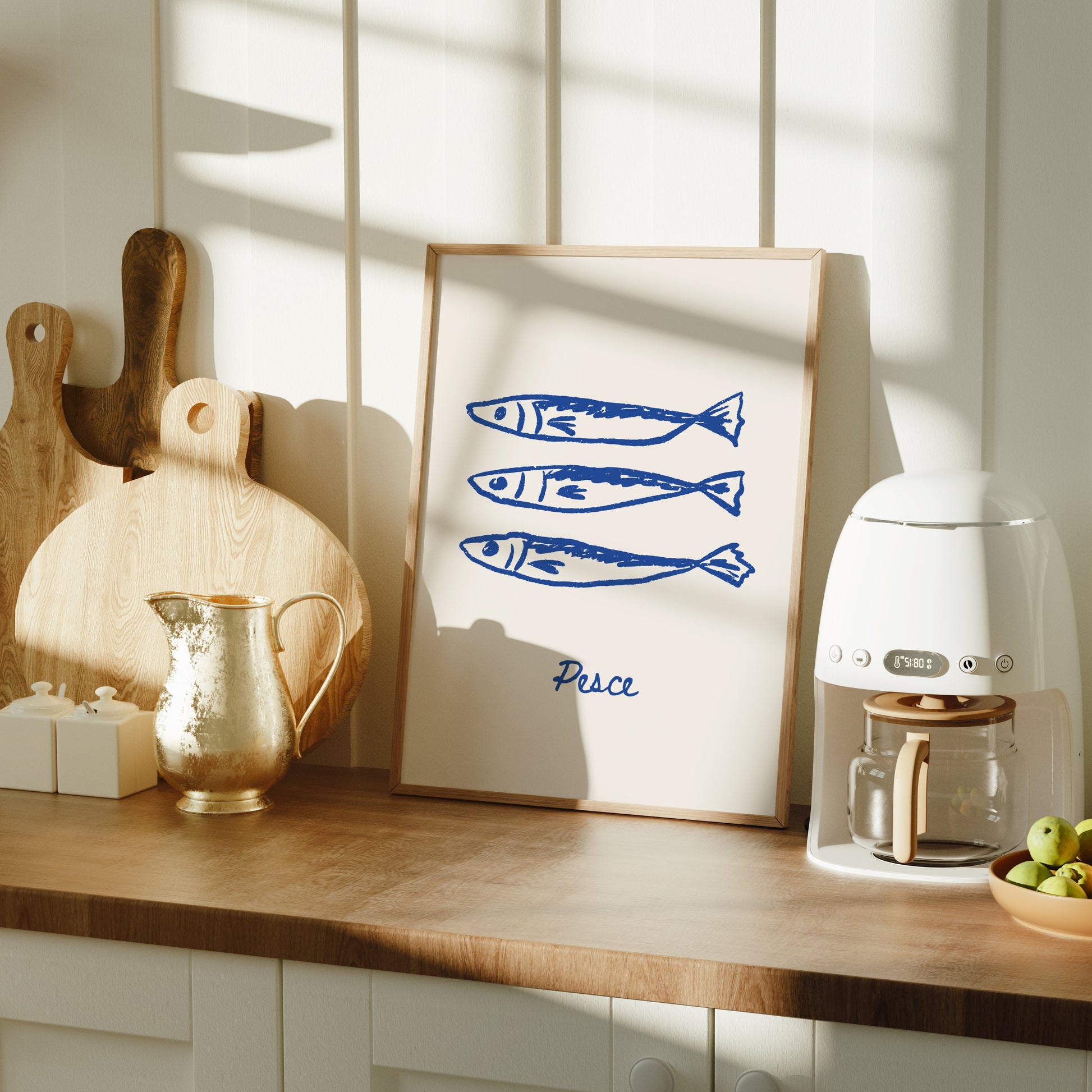 Kitchen counter with a coffee machine, cutting boards, and a framed picture of fish.