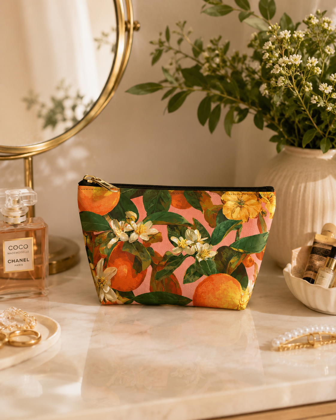 Makeup bag with floral design on a vanity table with mirror and perfume.
