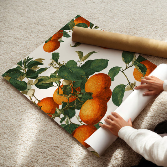 Person unrolling a large sheet of paper with an orange and green leaf pattern on a beige carpet.