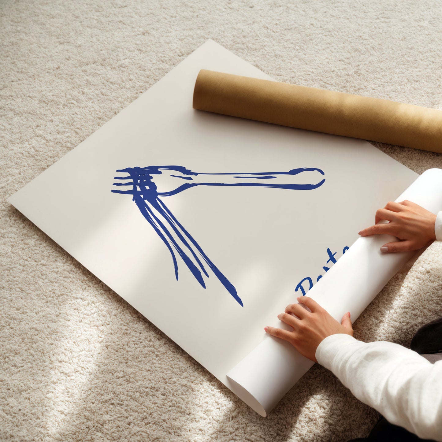 Person unrolling a large poster with blue pasta artwork on a beige carpet