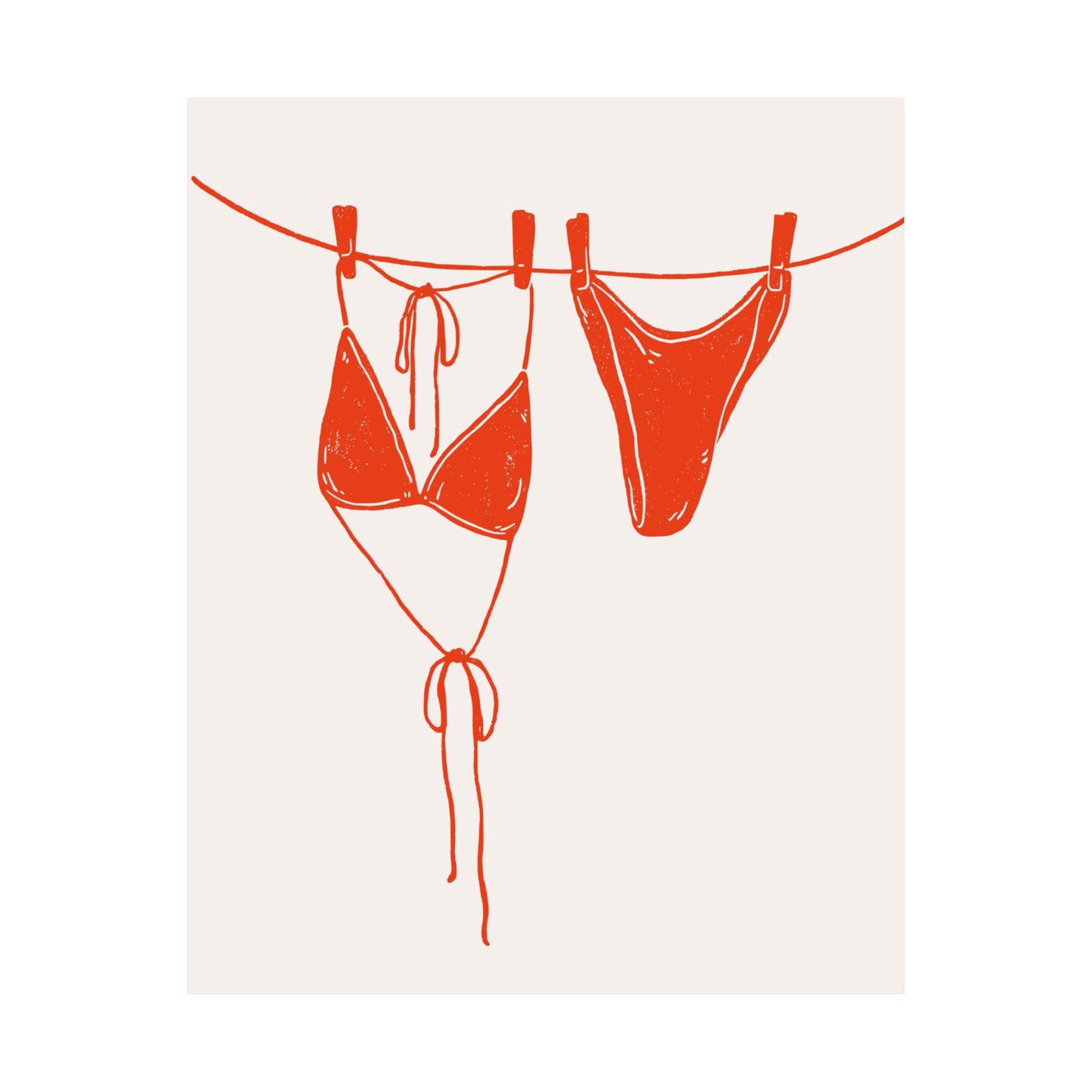 Red bikini hanging on a clothesline against a white background