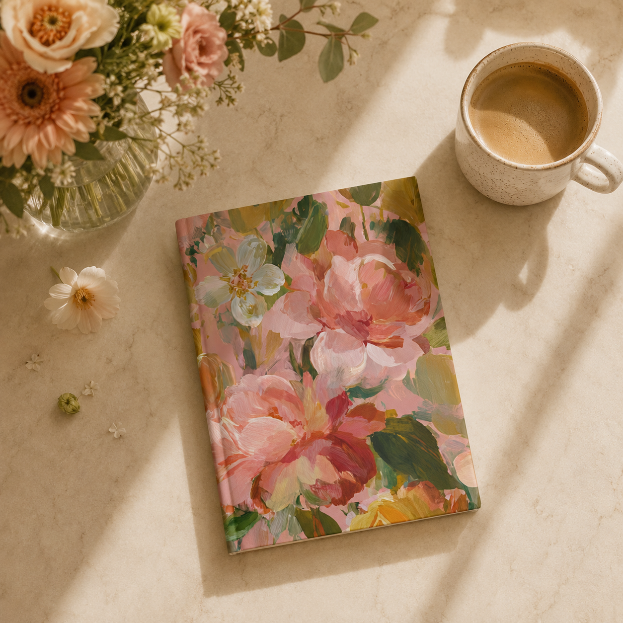 Floral notebook with a cup of coffee and flowers on a light surface