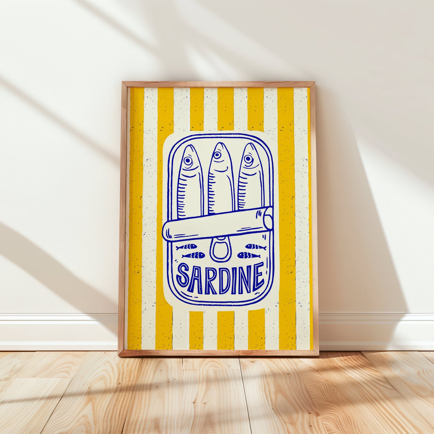 Framed artwork with a yellow and white striped background and blue sardine text on a wooden floor.