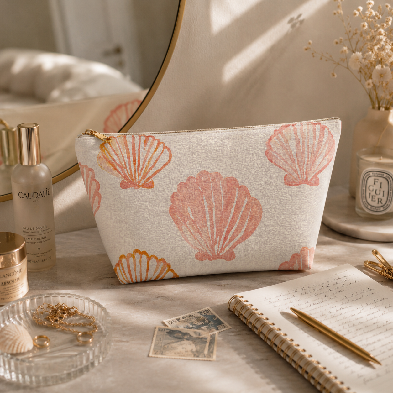 Cosmetic bag with shell pattern on a table with beauty products and stationery.