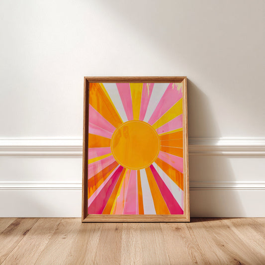 Framed abstract art with a sun design on a white wall.