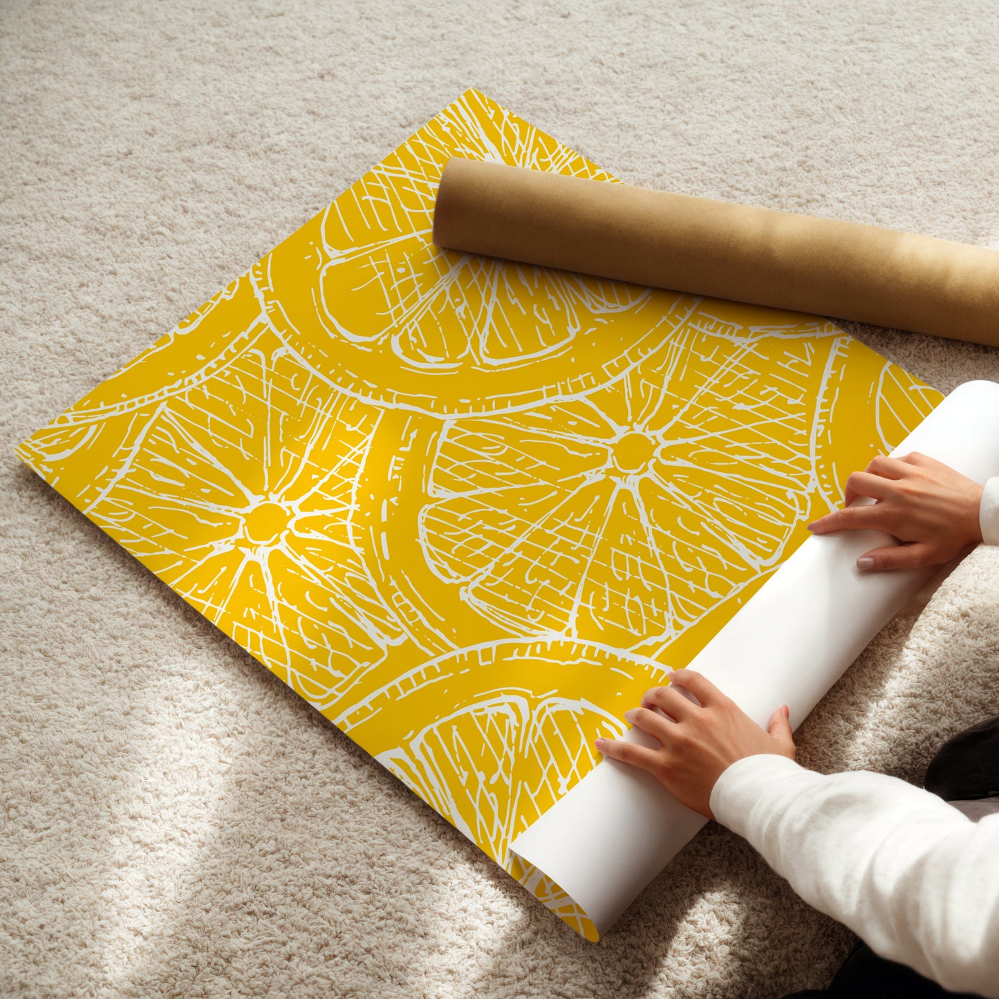 Person unrolling a yellow lemon slice poster on a light-colored floor