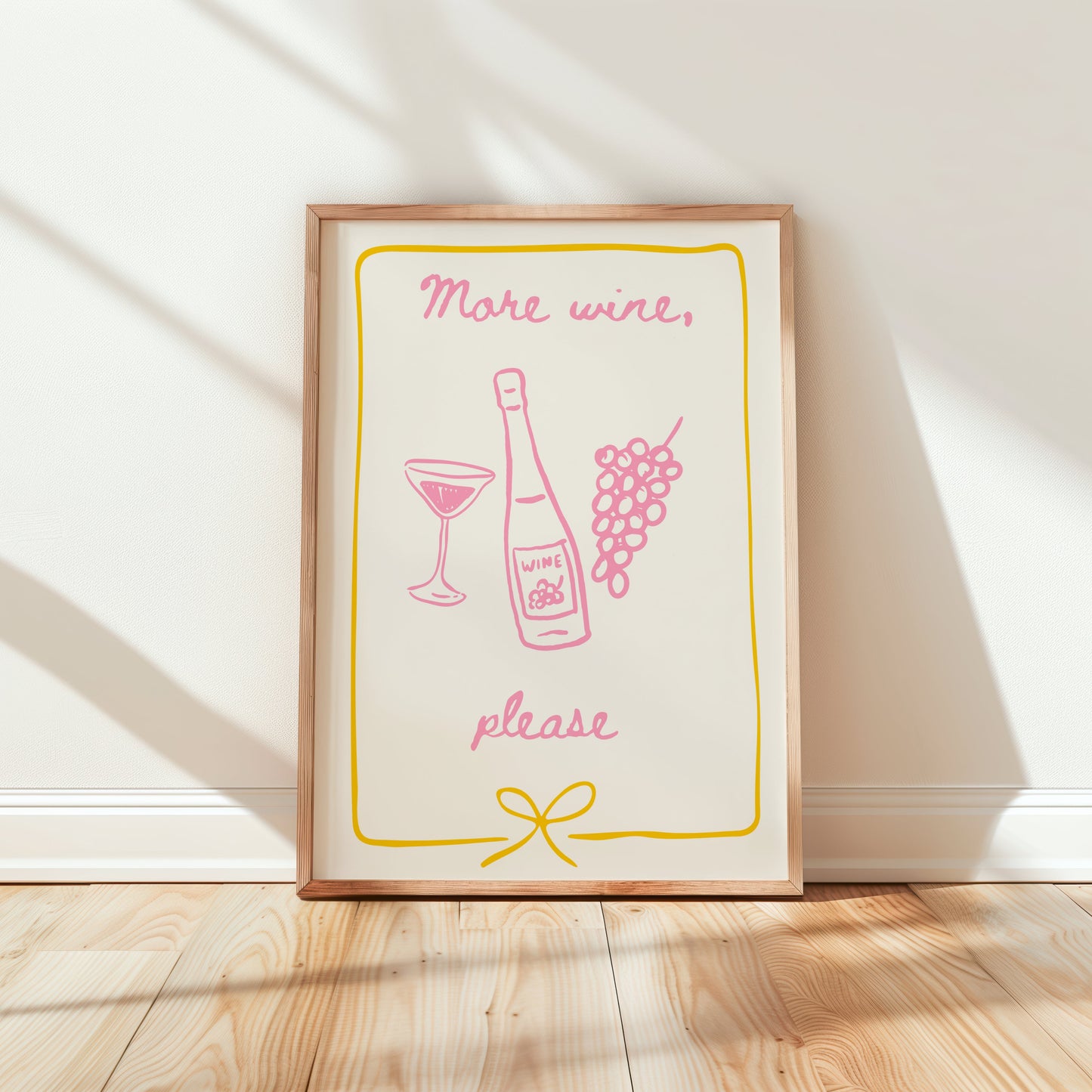 Framed print with 'More wine, please' text and graphics on a white wall.