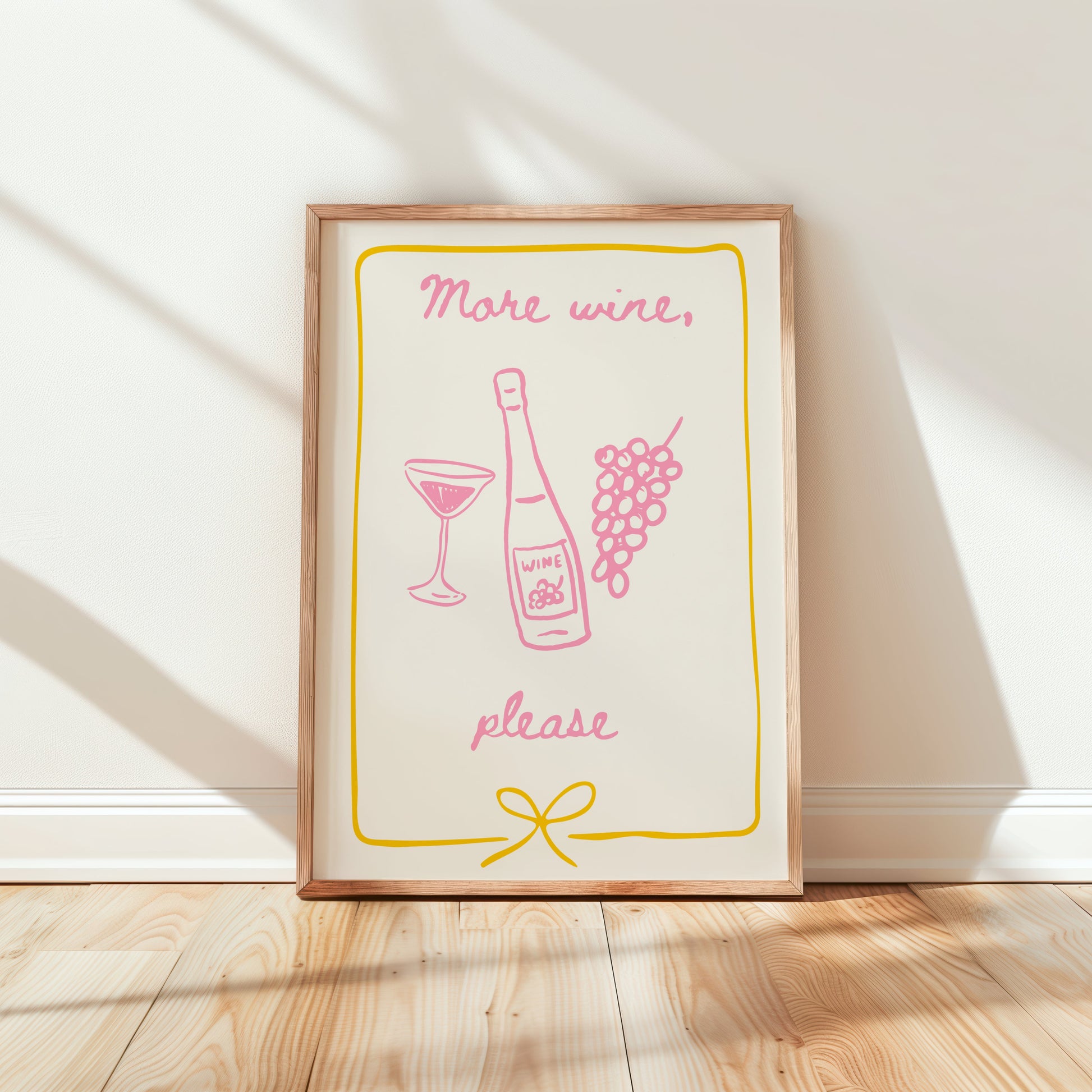 Framed print with 'More wine, please' text and graphics on a white wall.