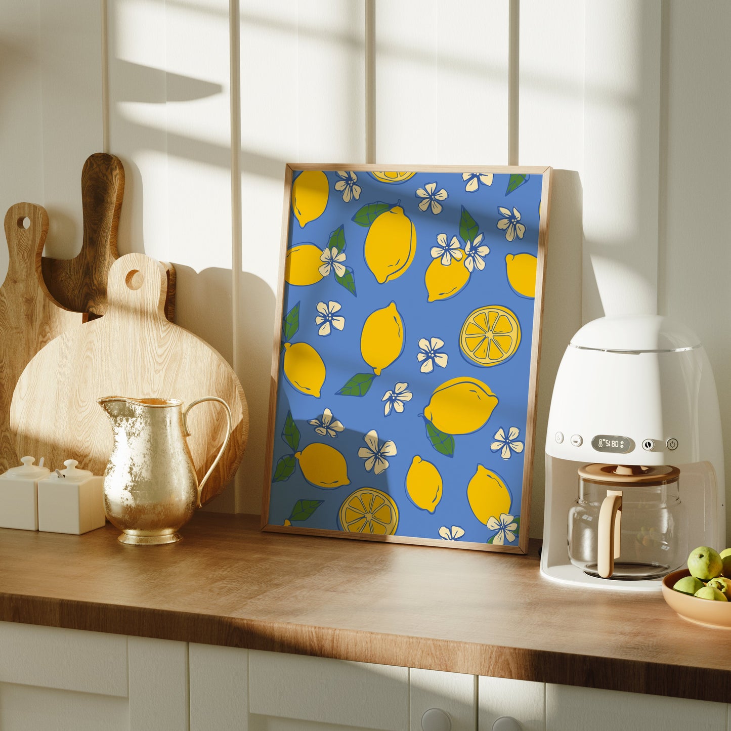 Kitchen counter with a lemon-patterned illustration, coffee maker, and fruit bowl.